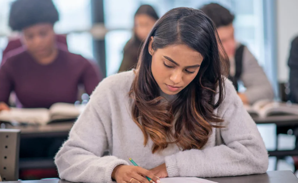 Alternante en situation de handicap invisible en master 2, en train de travailler dans une classe
